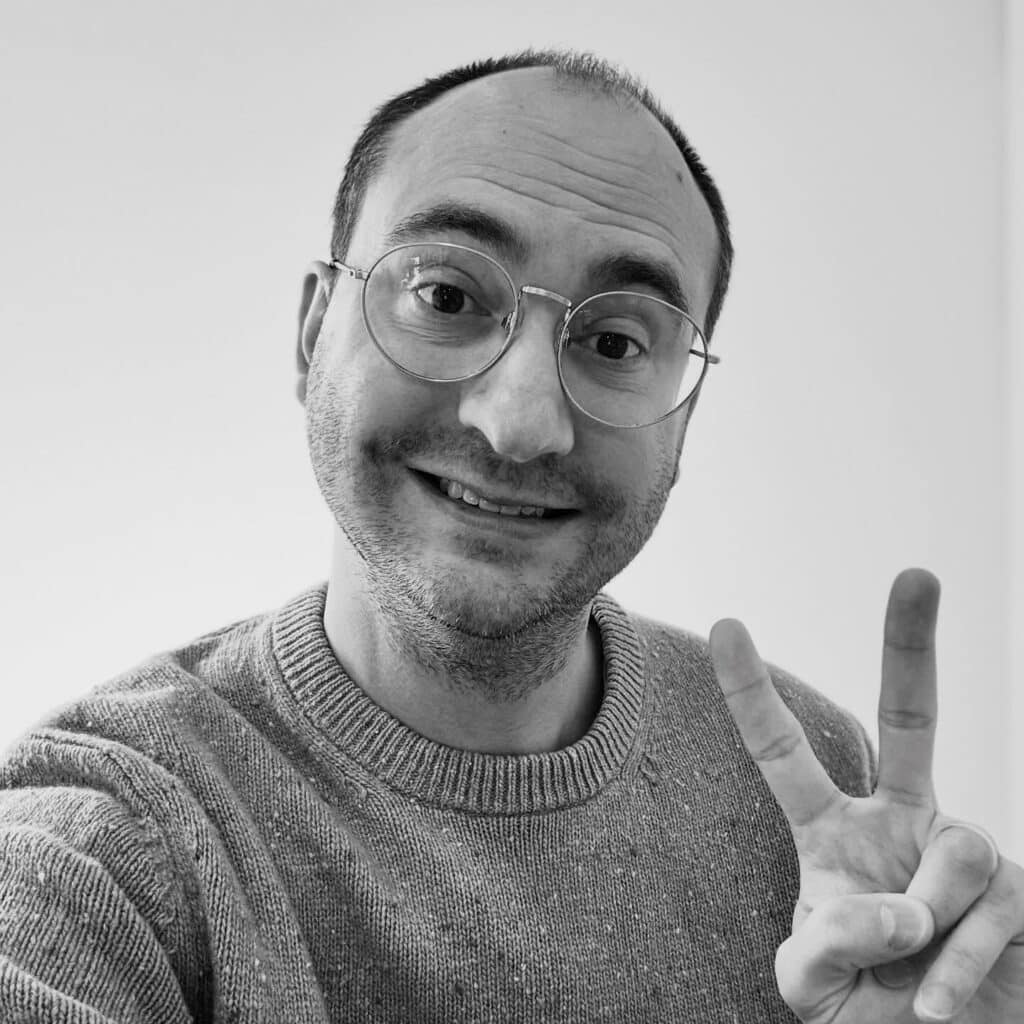 Zach smiling with Peace Sign in black and white